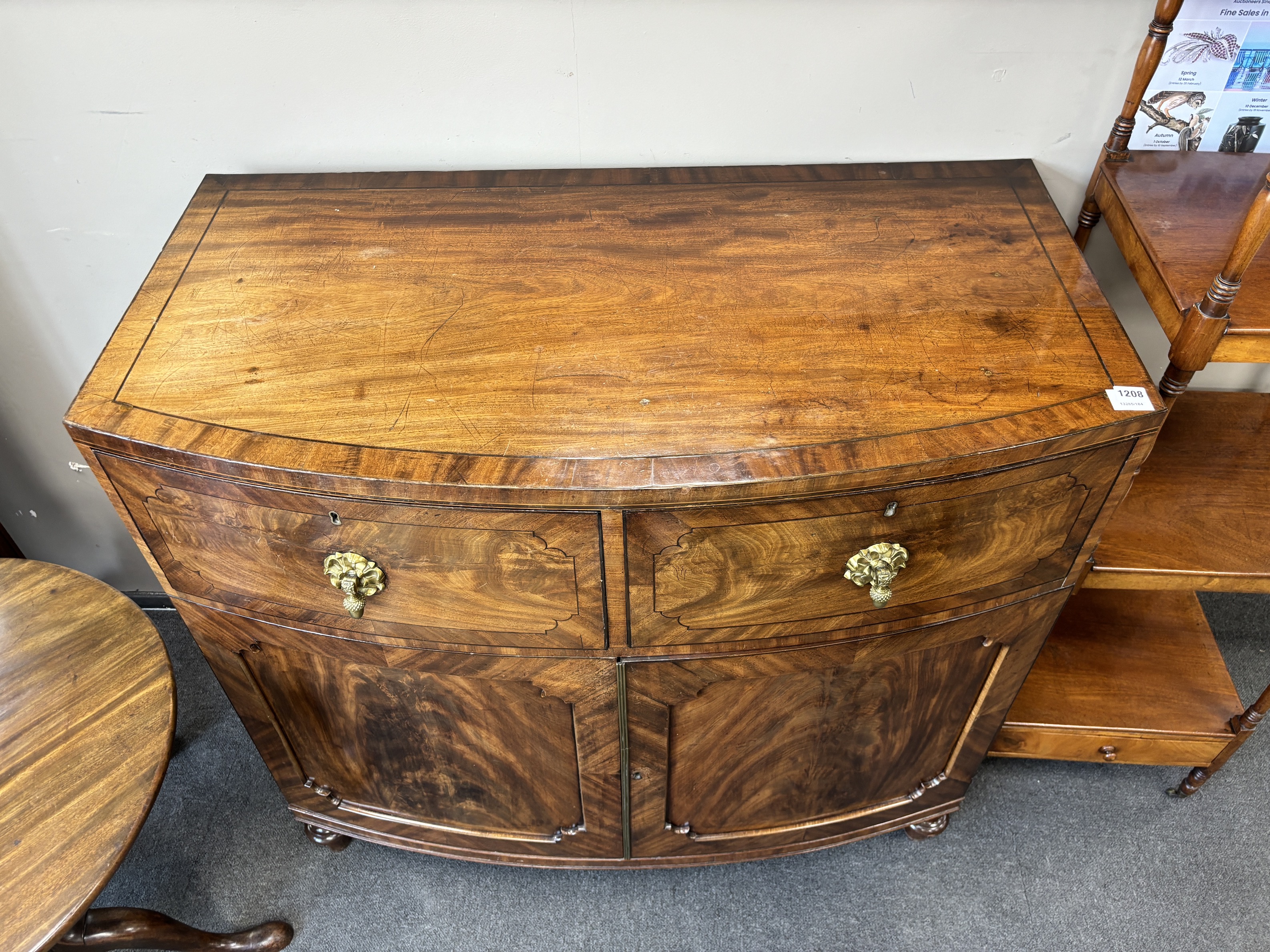 A George IV flame figured mahogany bowfront press cupboard, width 115cm, depth 61cm, height 108cm